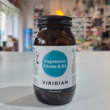 Bottle of Viridian Magnesium Citrate & B6 supplement on a white surface with a blurred store background.