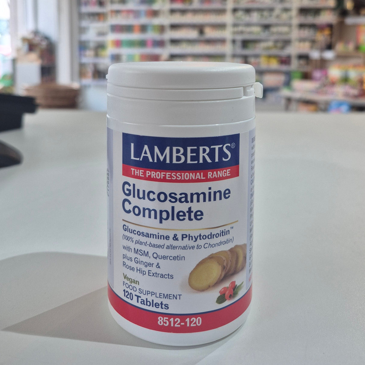 Lamberts Glucosamine Complete supplement container on a table with a blurred store background