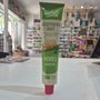 A tube of Tartex Vegetarian Pate with Herbs featuring a green and beige label with a pink cap, shown against a blurred background of a store interior.