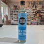 Bottle of Hunter Gatherer MCT oil on a white surface with a blurred store background