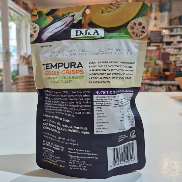 Packaging of DJ&A Tempura Veggie Crisps with ingredients and nutrition information on a blurred background.