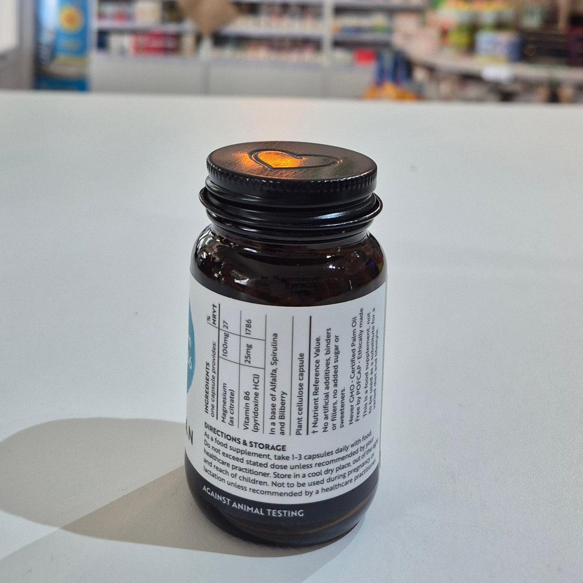 Bottle with label on a white surface, blurred background of shelves with products