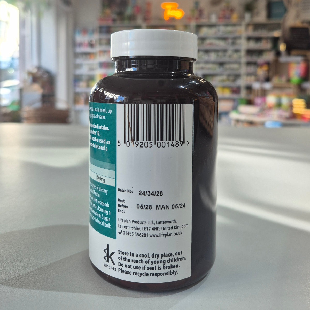 Vitamin supplement bottle with label on a counter in a store setting