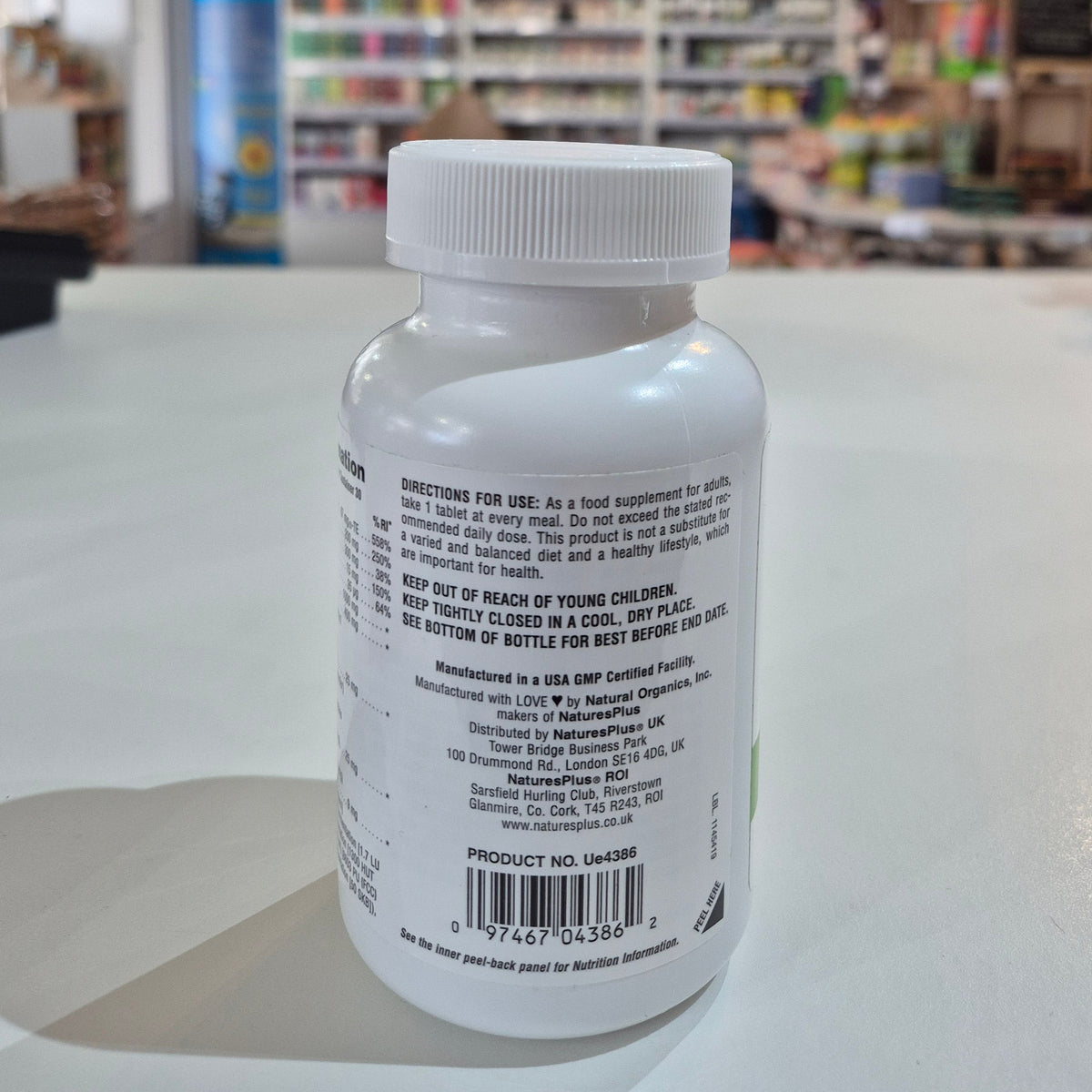 White bottle with label against a blurred indoor background