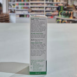 Eye drop container with label on a white surface, blurred store background