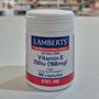 Lamberts Vitamin E supplement container on a table with a blurred background