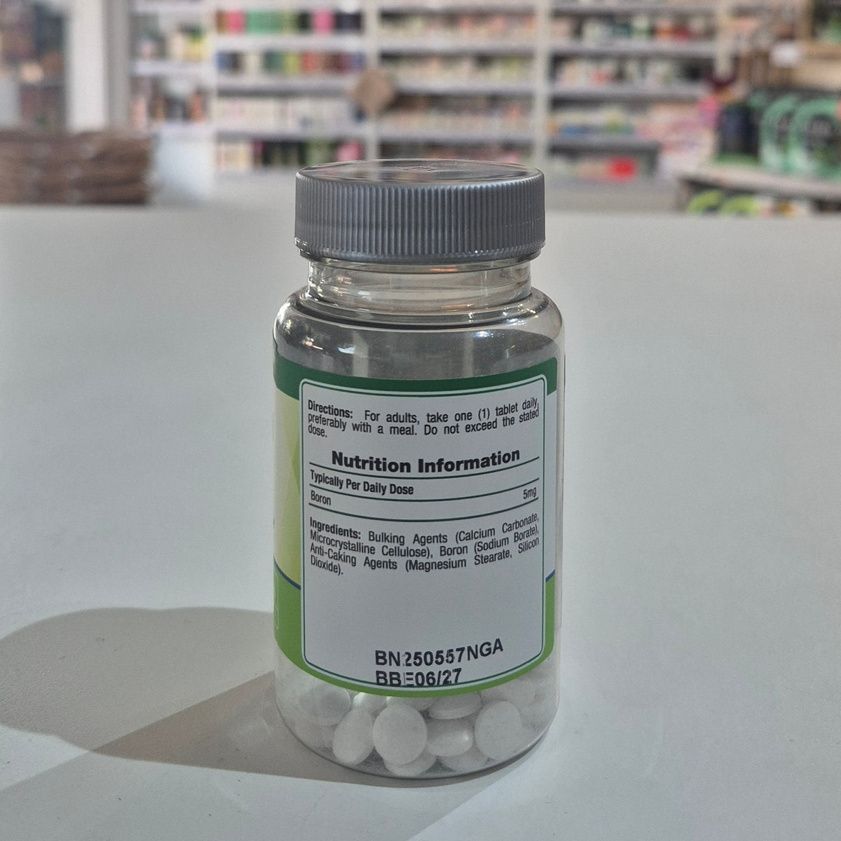 Bottle of supplements with a label on a white surface, blurred store background