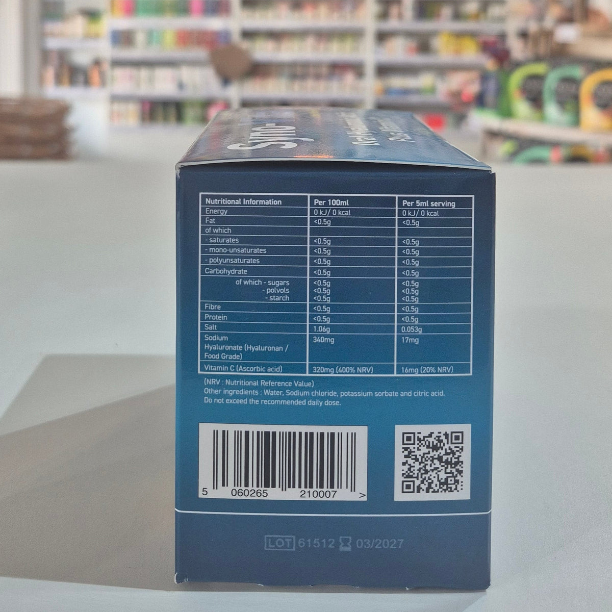 Back of a blue box with nutritional information and QR code on a blurred store shelf background