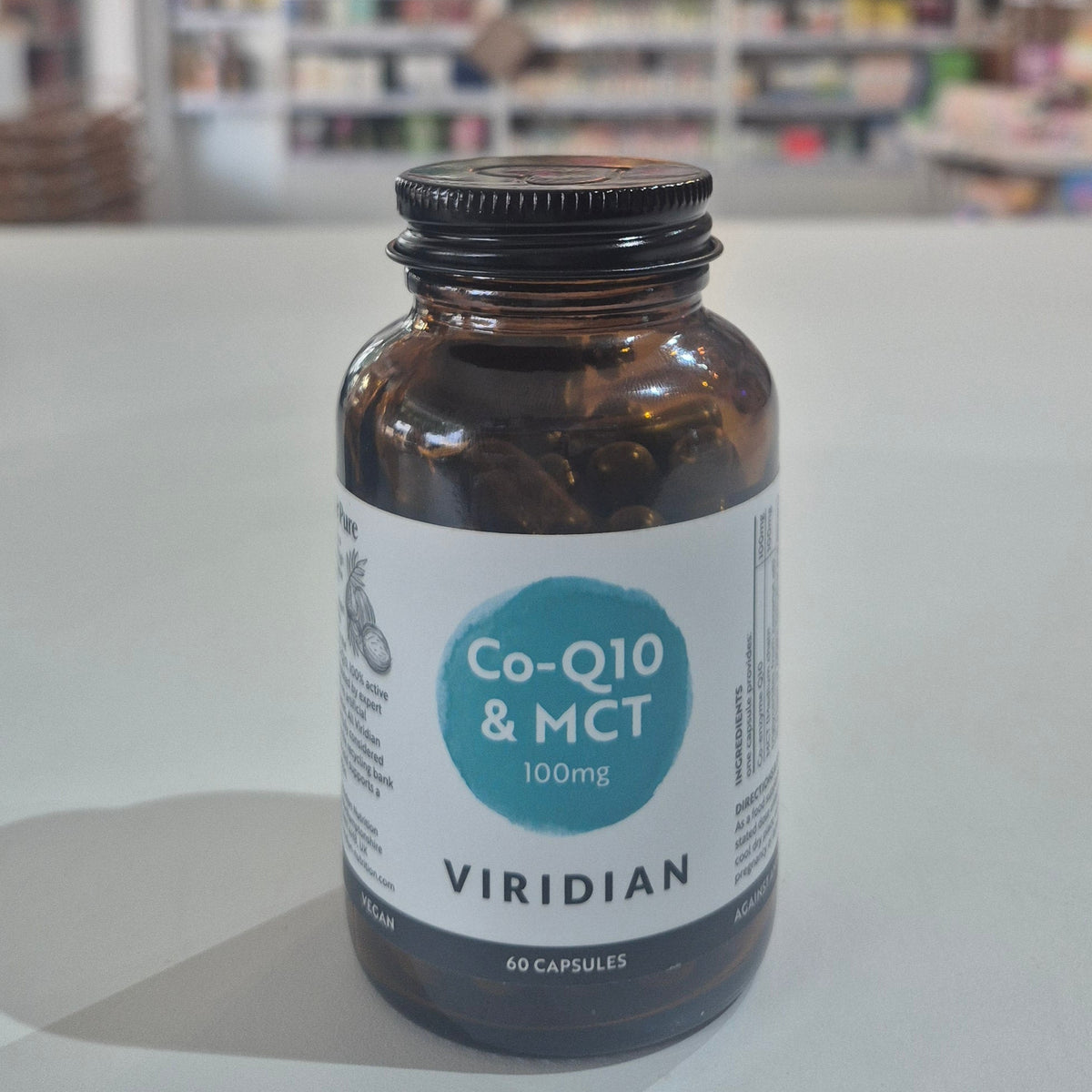 Bottle of Viridian Co-Q10 & MCT supplement on a shelf with a blurred store background